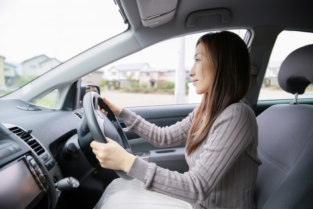 運転席で運転する女性